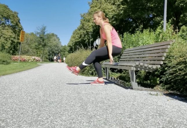 Vrouw traint bij een bankje langs een pad