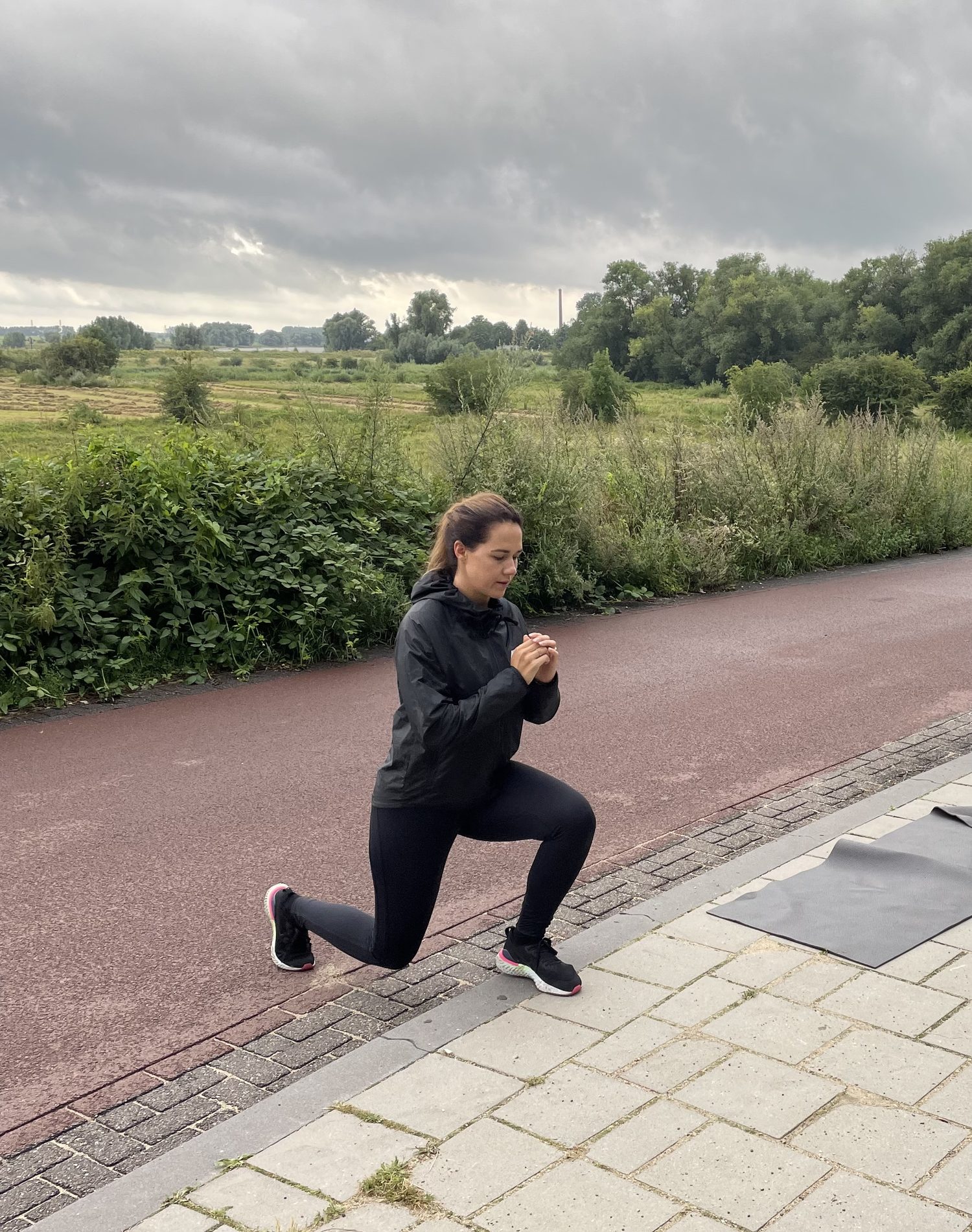 Vrouw maakt een uitvalspas op de stoep
